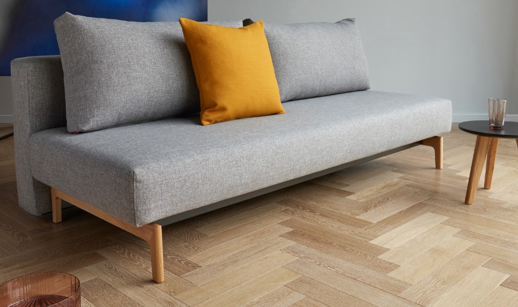 Trym bäddsoffa, klädd i tyg 521 Mixed Dance Grey, som soffa